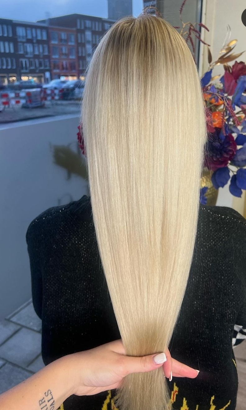 Afgewerkt lang, glad blond haar, van achteren gefotografeerd